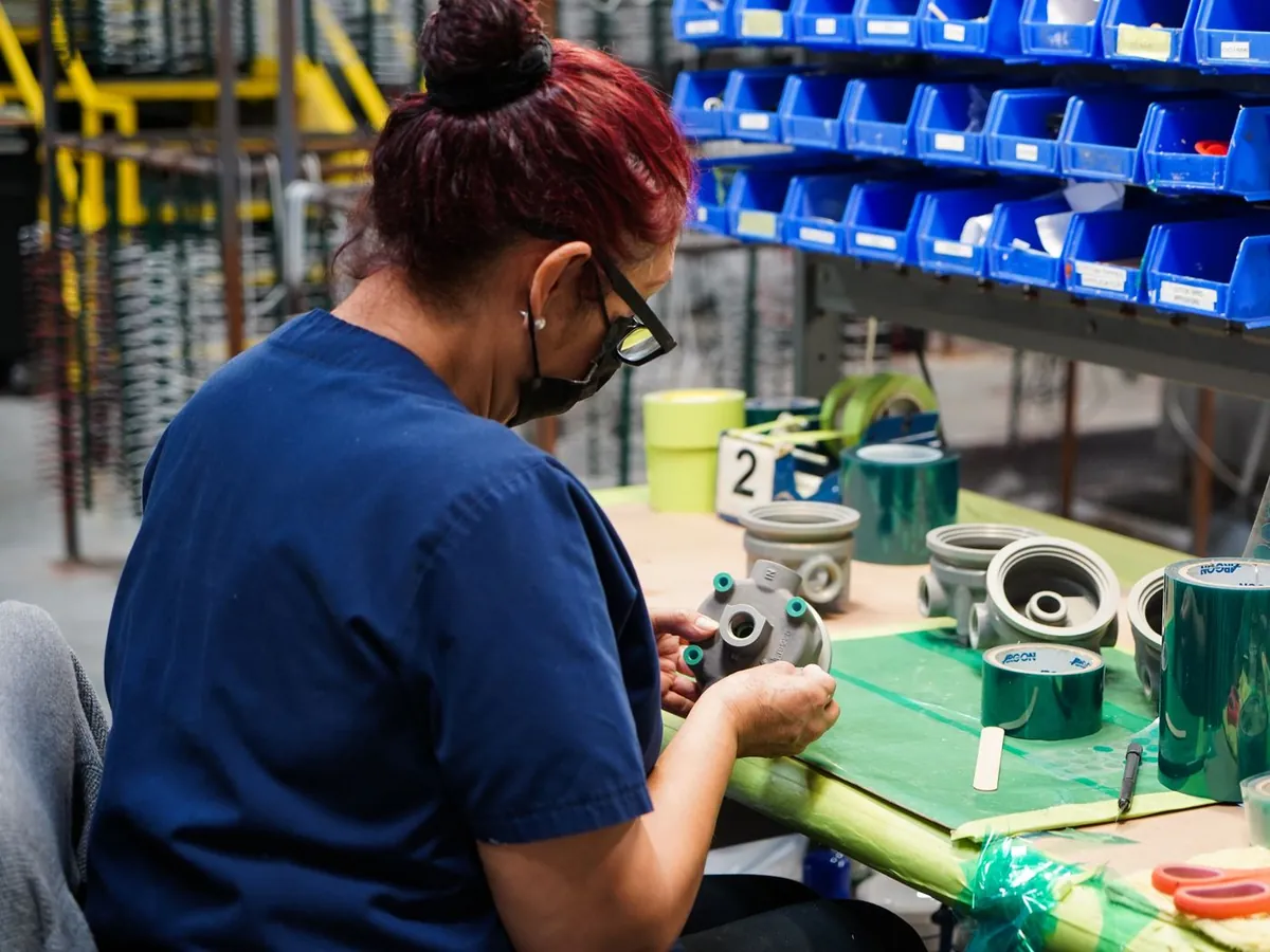 Technician masking a part before processing