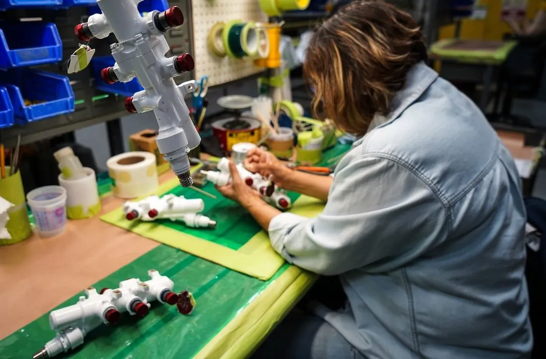 Technician masking a manifold at a workstation